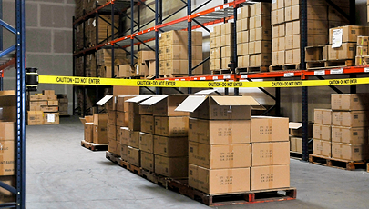 image of cardboard boxes in warehouse behind safety barrier