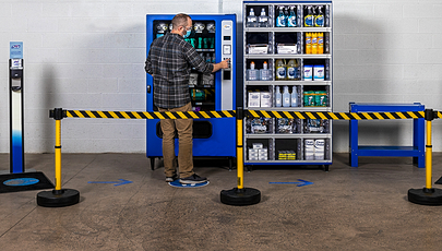 image of person using vending machine behind safety barrier